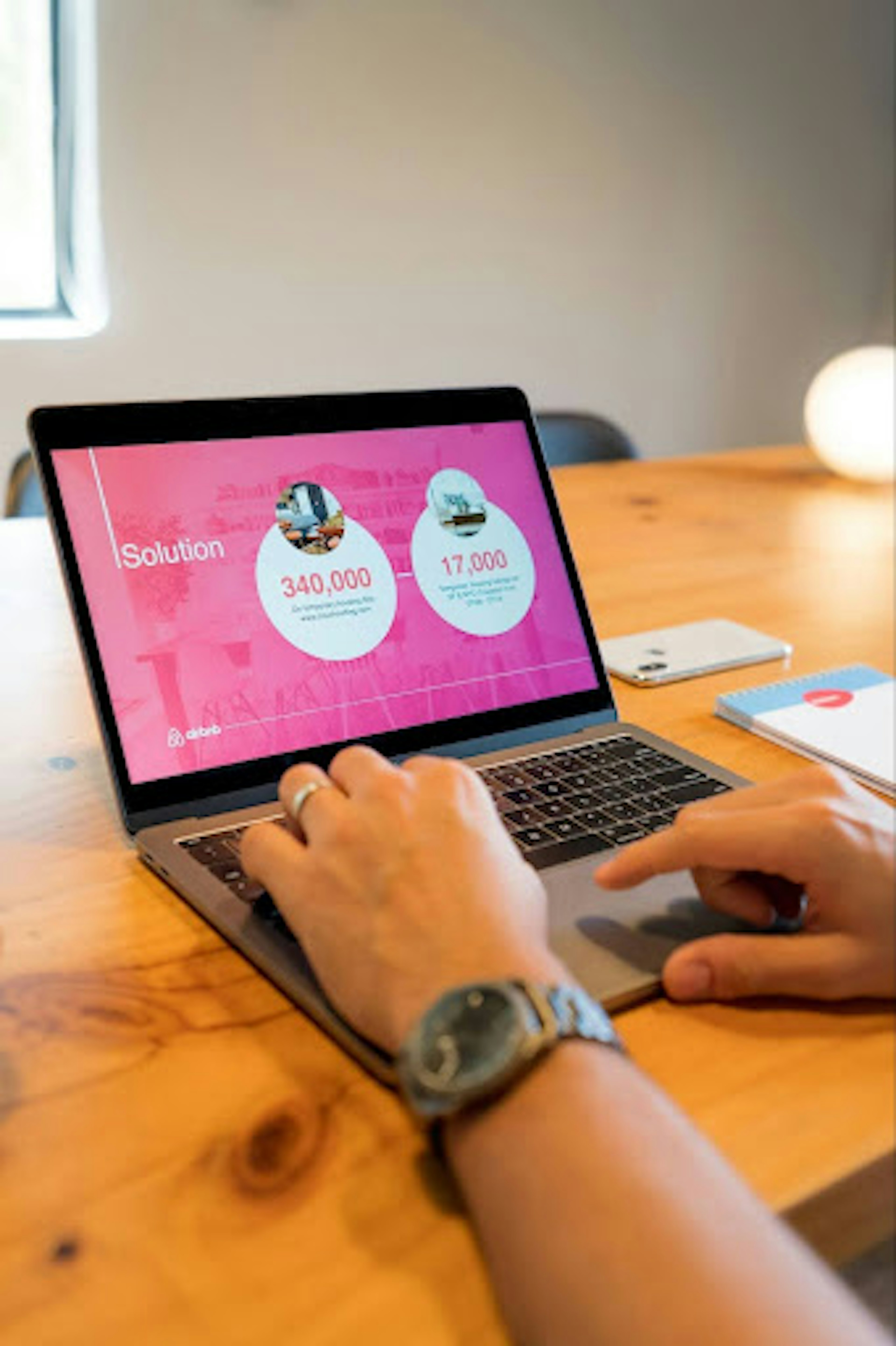 Pair of hands clicking away on a laptop. Laptop screen shows a slide deck.